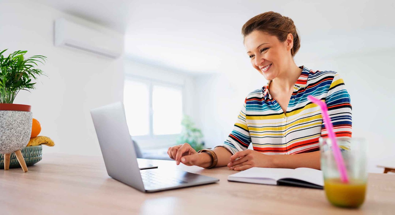 A lady sat at a desk working on a laptop