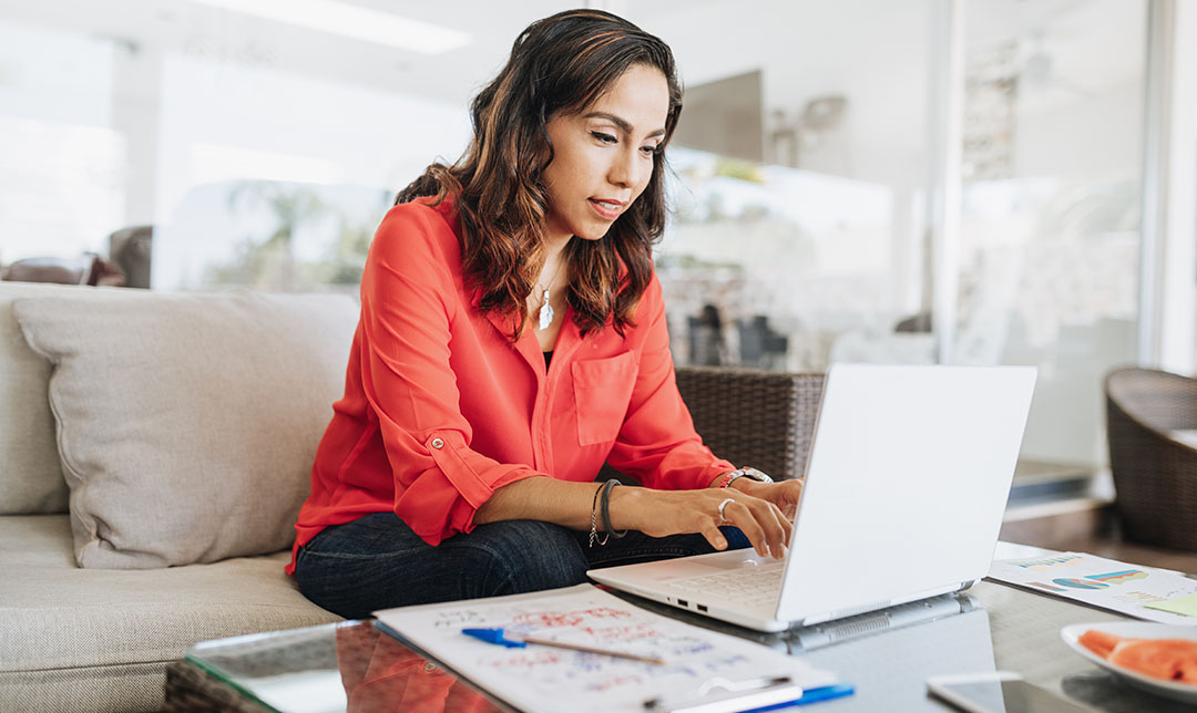 Lady sat on a sofa using a laptop