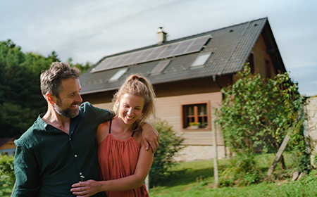A couple standing in front of a home with solar panels