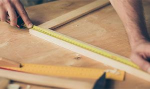 Measuring up for wood joinery in a workshop.