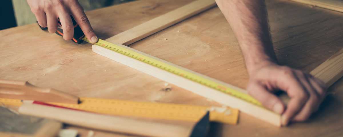 Measuring up for wood joinery in a workshop.