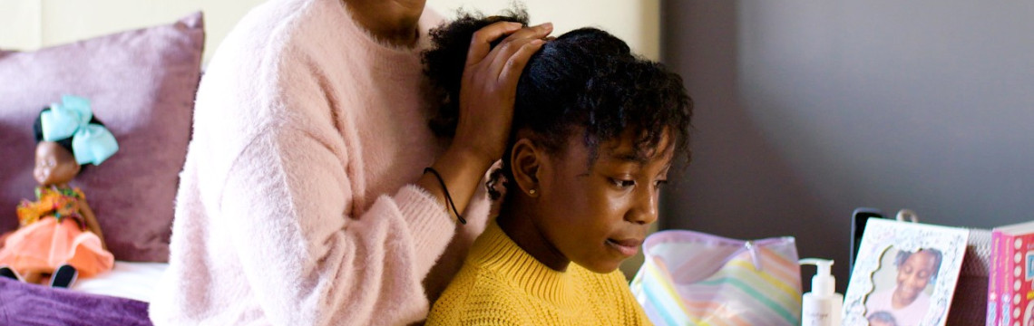 A child having her hair styled.