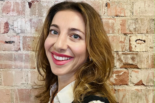 Savannah Price, the CEO and founder of Serene, standing in front of a brick wall and smiling.