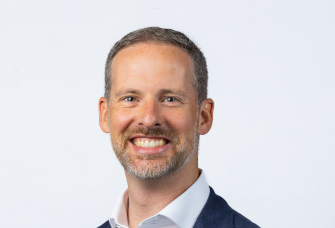 A professional headshot of Paul Valente.