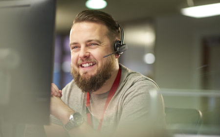 Person wearing a headset working at a computer