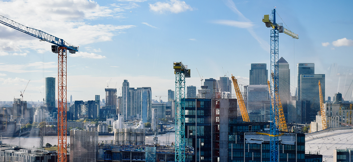A photo of a construction skyline featuring a number of cranes and skyscrapers