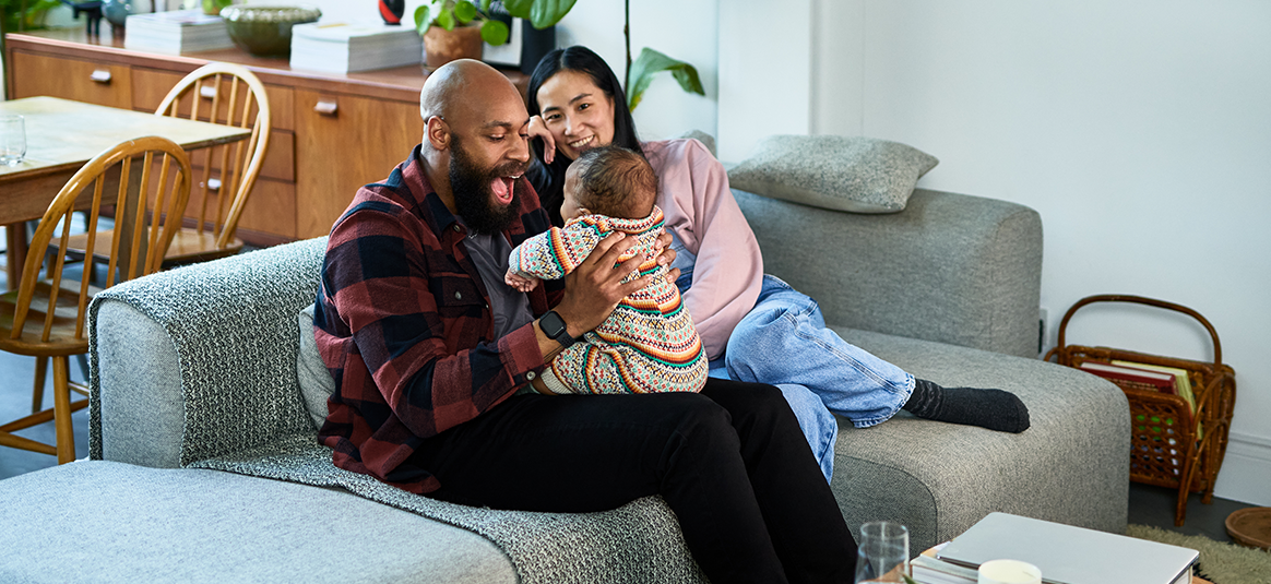 Photo of a couple on a sofa with a baby