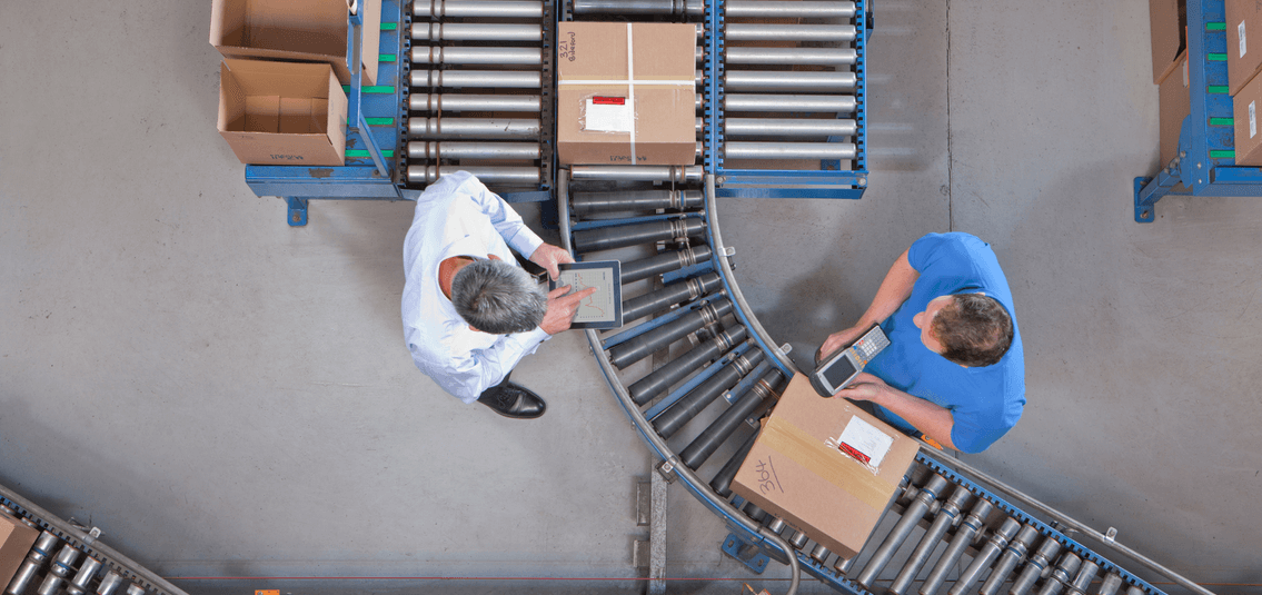 Aerial view of two workers scanning packages down the assembly line