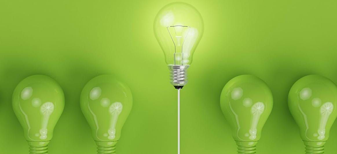 photo of green light bulbs with one clear and elevated