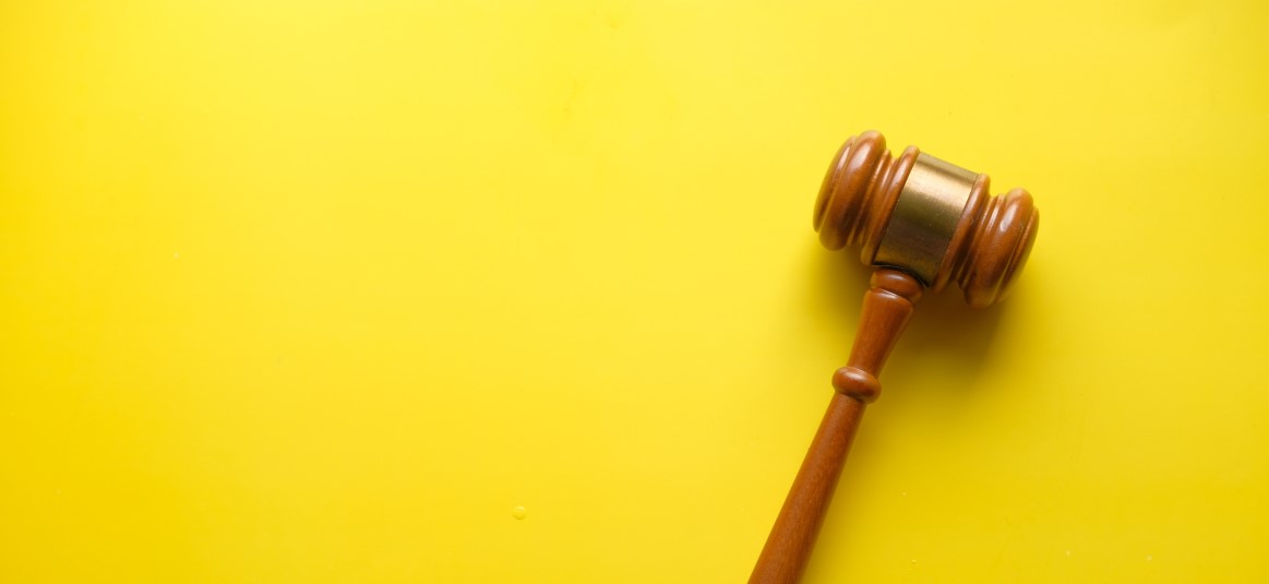 wooden gavel against yellow background
