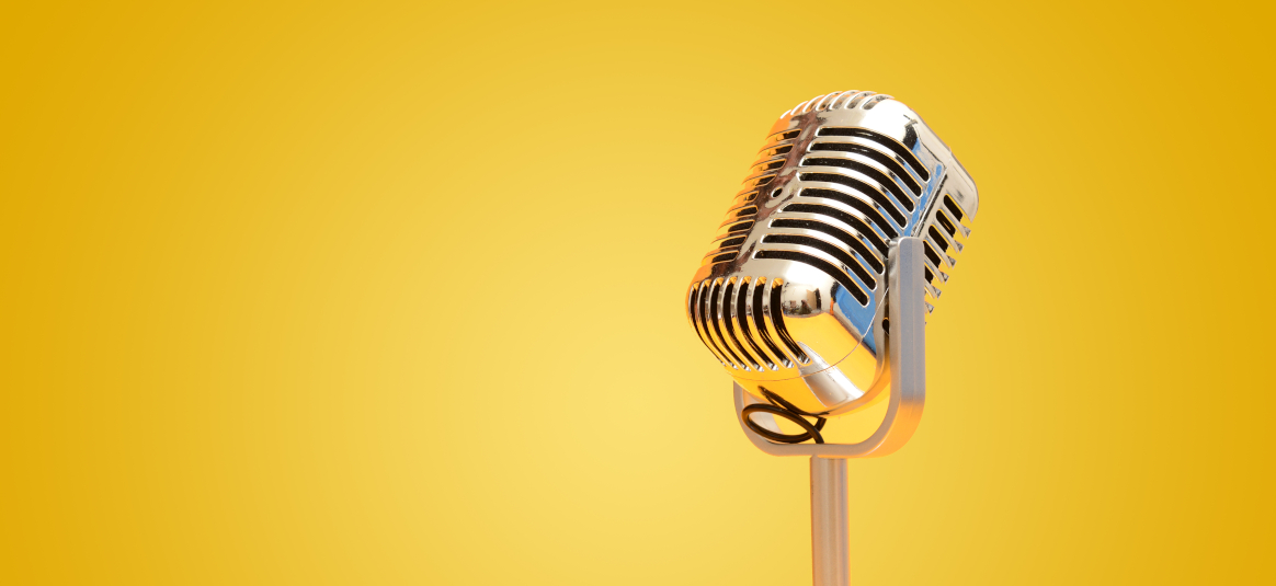 Photo of a chrome microphone on a yellow background