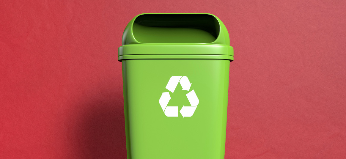 Photo of green recycling bin on a red background