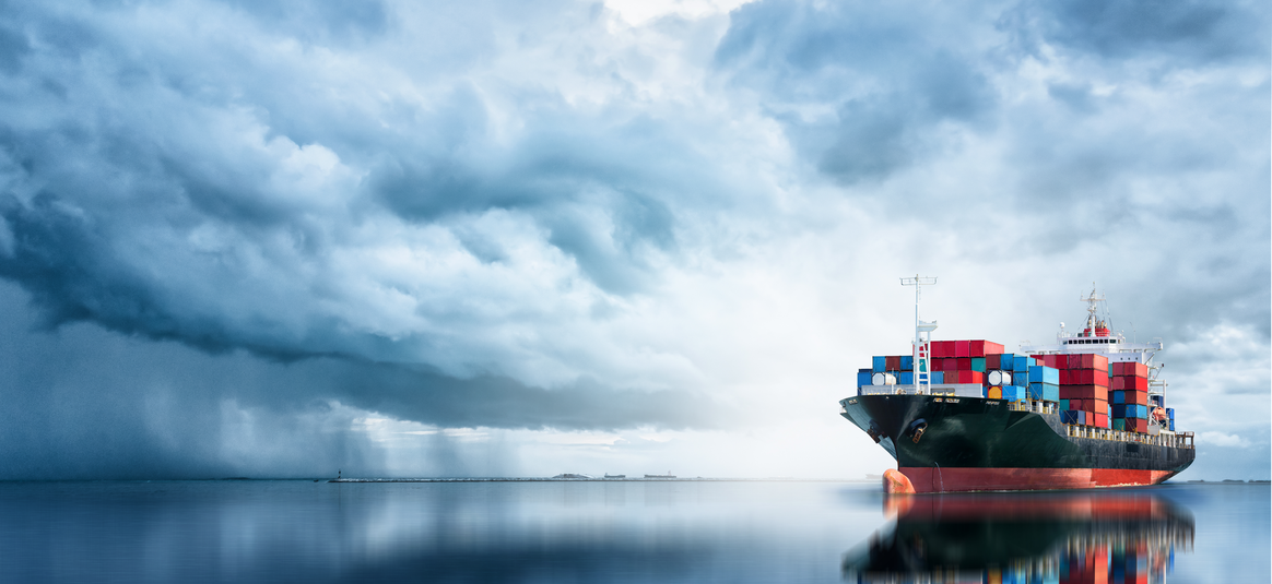 Cargo Ship sailing surrounded by cloudy skies