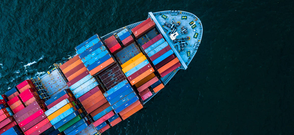 Container ship with full cargo traverses trade waters.