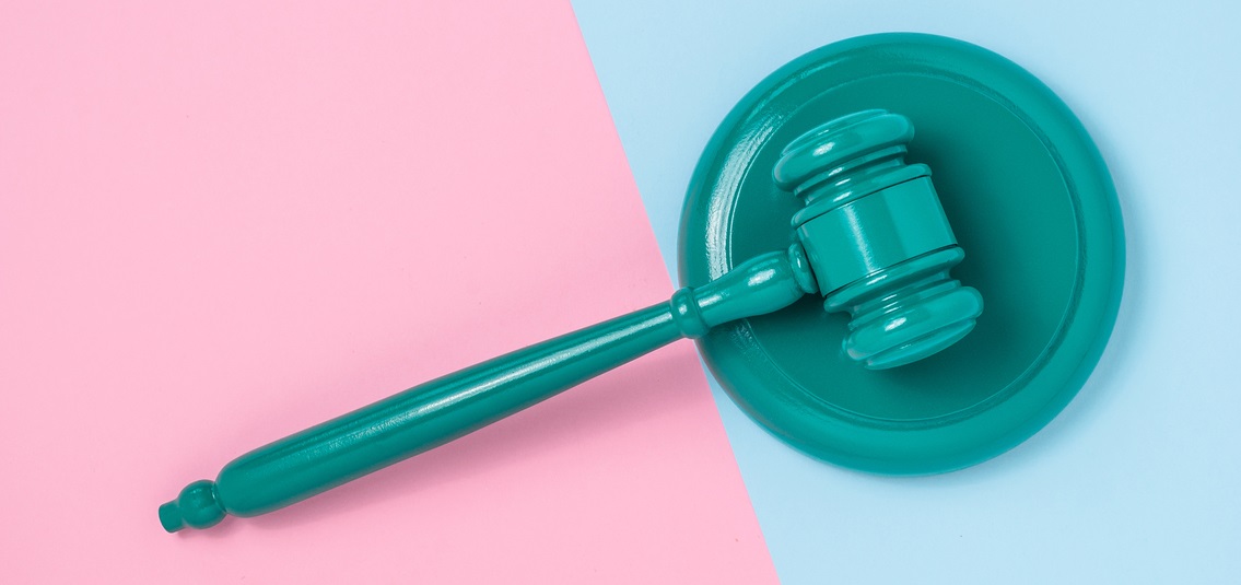 a gavel resting on a pink and blue surface