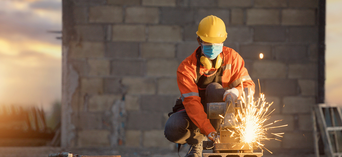 Picture of a man working at a construction site wearing protective gear