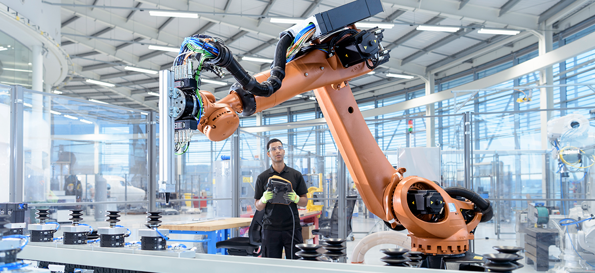 Photo of a person operating a manufacturing robot
