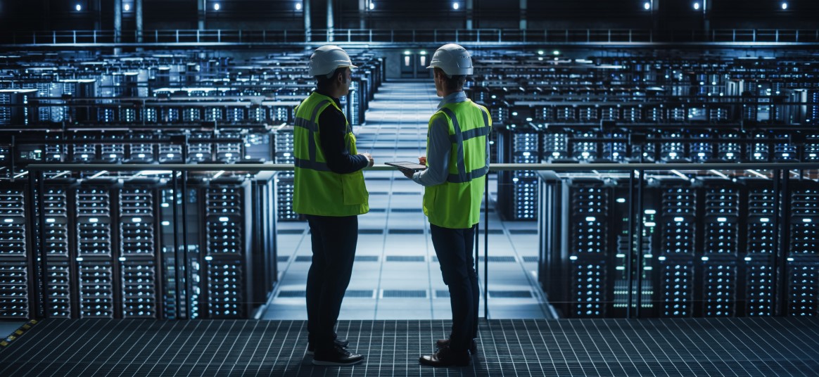 Digital infrastructure: server farm site under assessment by two people in conversation.