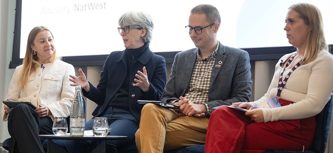 Work colleagues have a discussion around small round table