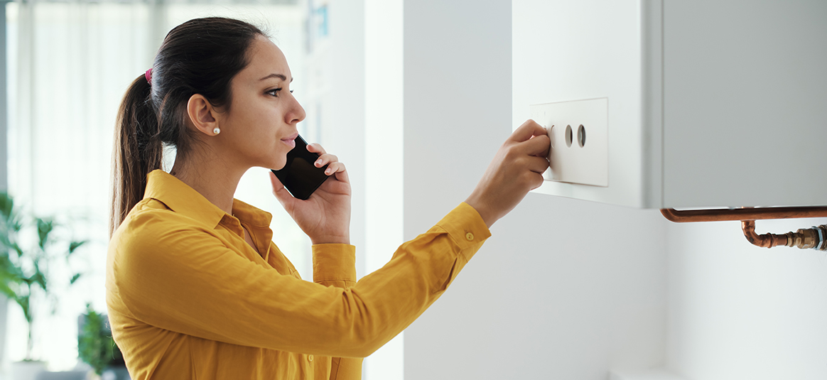 Photo of woman on telephone setting a boiler