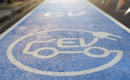 Photo of an EV symbol painted on tarmac. 