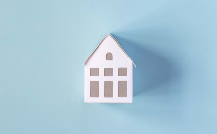 Photo of a model house on a blue surface
