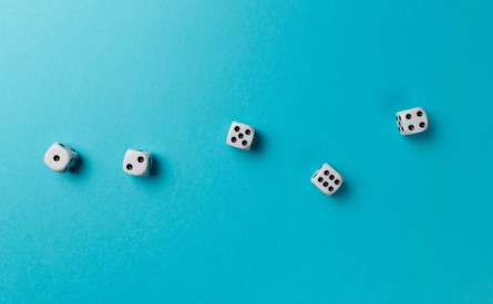 Photo of five dice on a blue surface