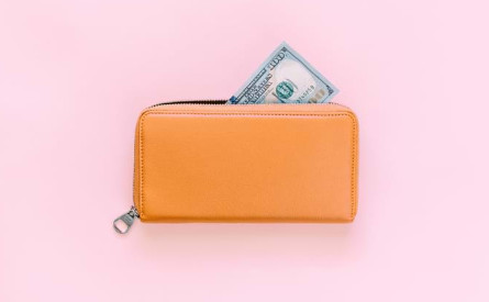 Photo of a yellow wallet on a pink background