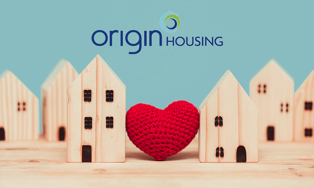 Photo of the Origin Housing logo above wooden house and a red knitted heart