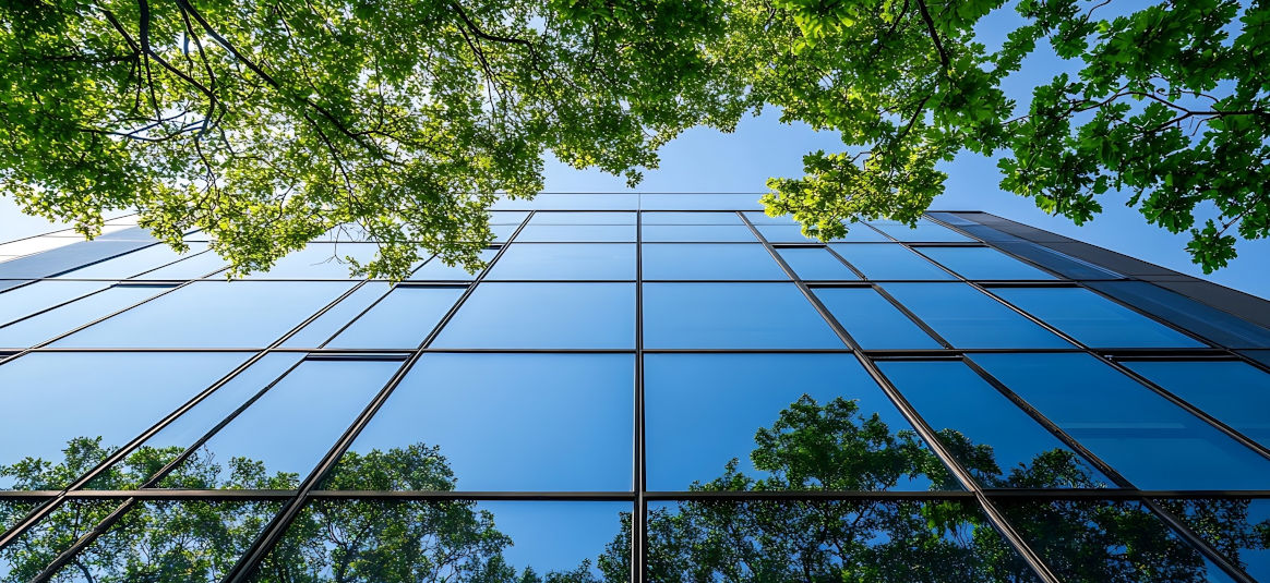 Upward looking image of the blue sky reflected in glass windows. 