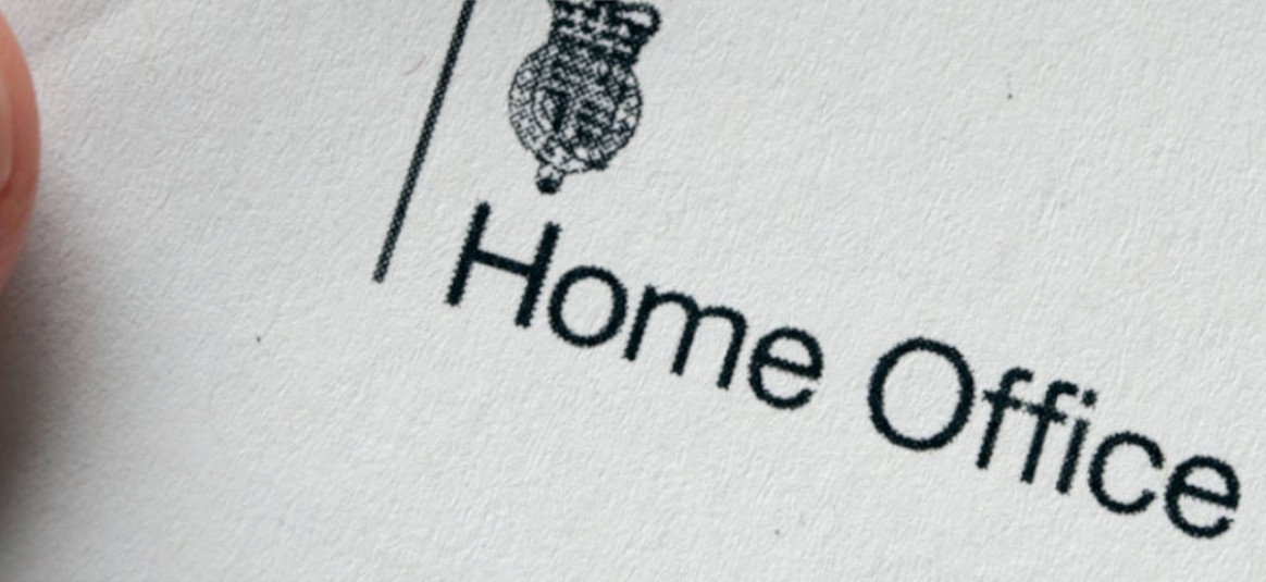 'Home office' printed on held paper, with official crest.
