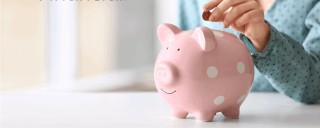 Photo of a pink piggy bank and a child’s arm