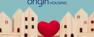 Photo of wooden houses and a red knitted heart