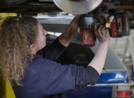a woman mechanic fixing a car