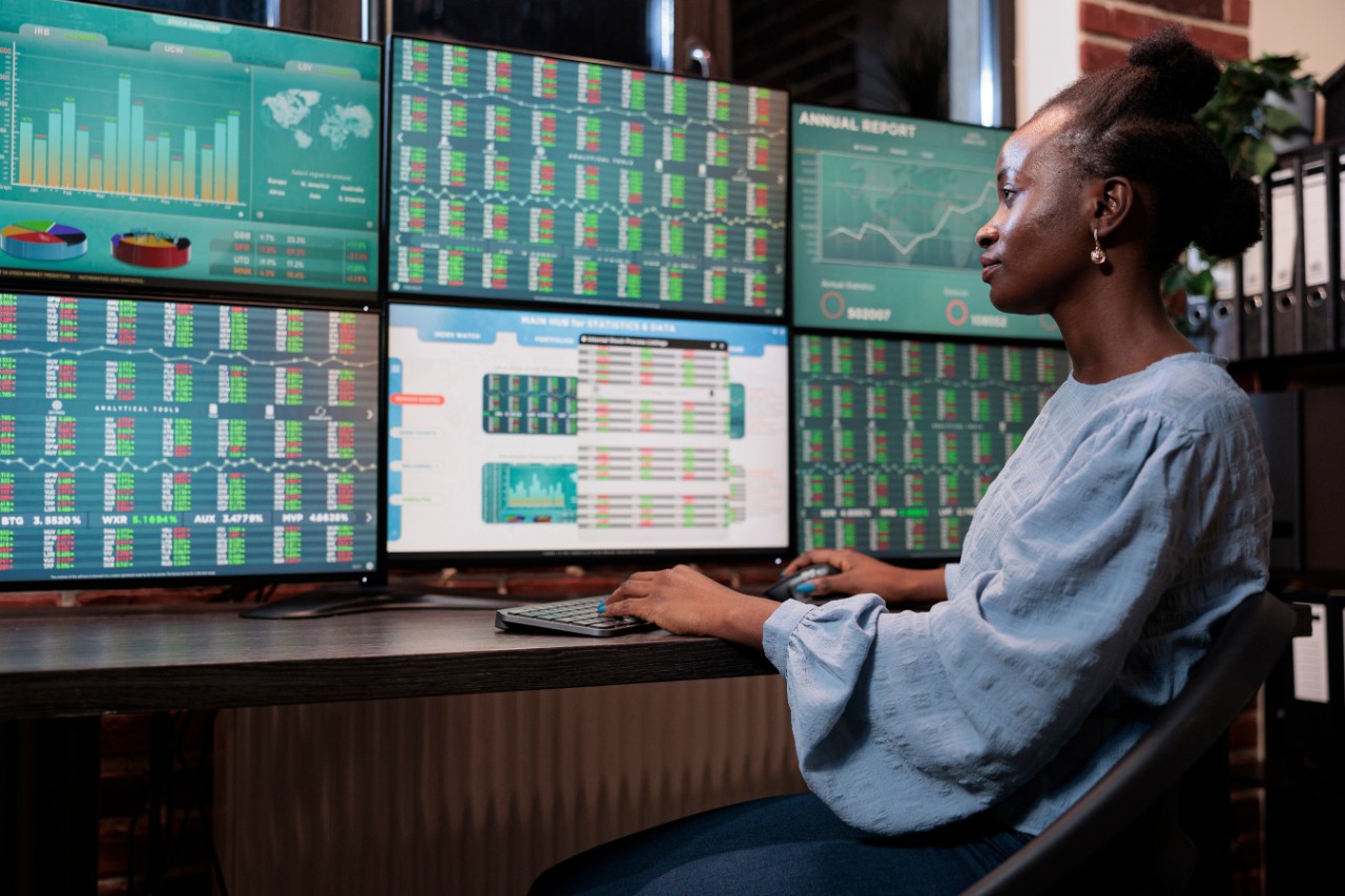 a woman using 6 monitor screens