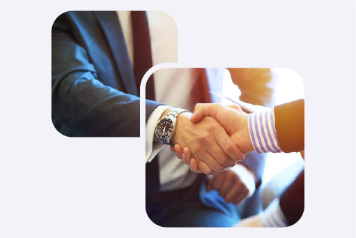 Two people wearing suits shaking hands. 