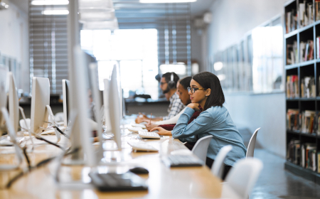 People in a brightly lit computer lab looking at computer screens.