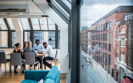 FIve people sitting around a table in an informal office several floors above street-level.