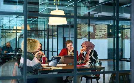 A group of people having a meeting in a modern looking office environment.
