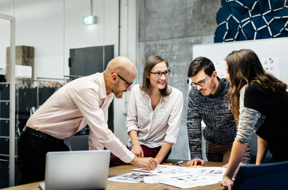 A group of professionals in a meeting room looking over documents together.