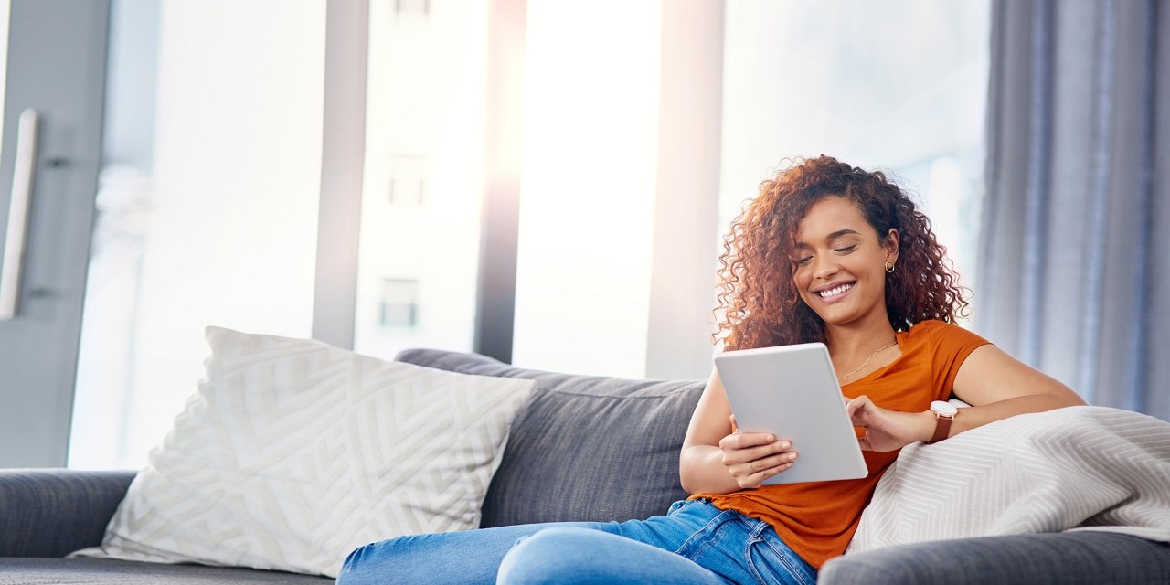 Woman sitting on her couch with an iPad