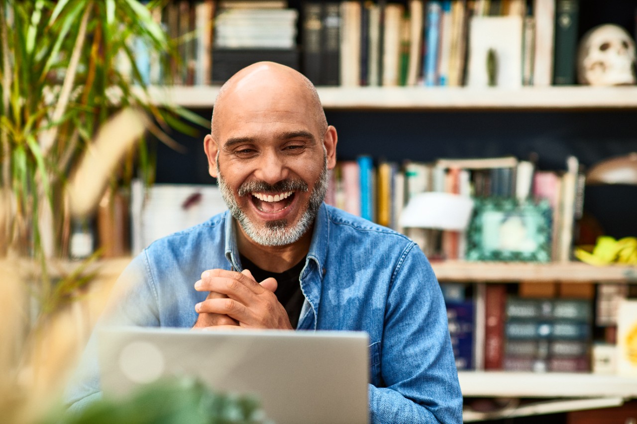 Man sitting smiling on his laptop