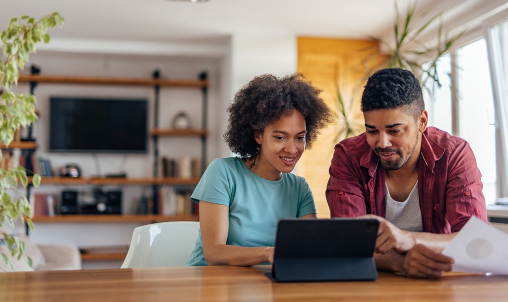 Couple sitting with iPad smiling