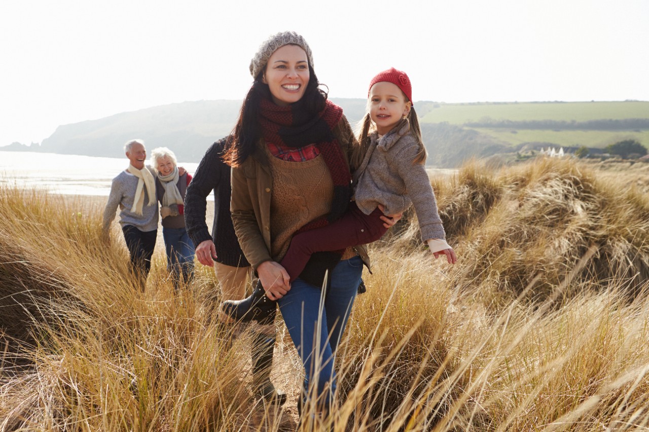 A NatWest Premier customer walking near the sea wither her family and parents