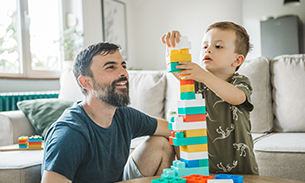 father and child playing with building blocks